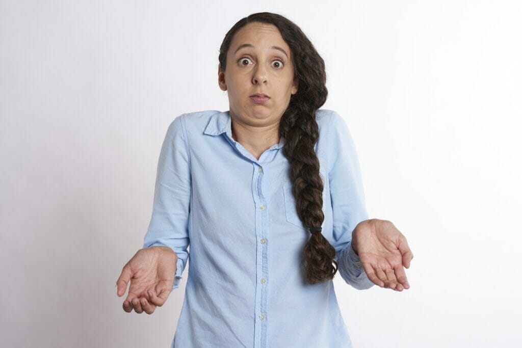Image description: lady with hands outstretched looking visibly confused